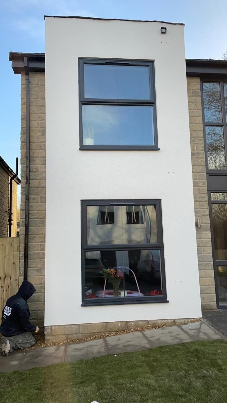 Two-storey white through-coloured render with stone detailing