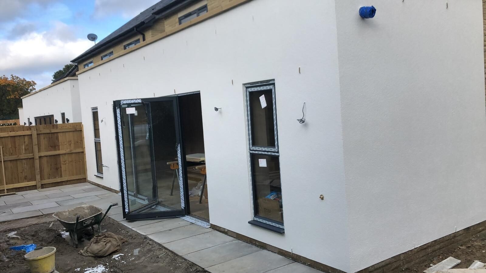 White rendered rear extension with bifold doors and new patio