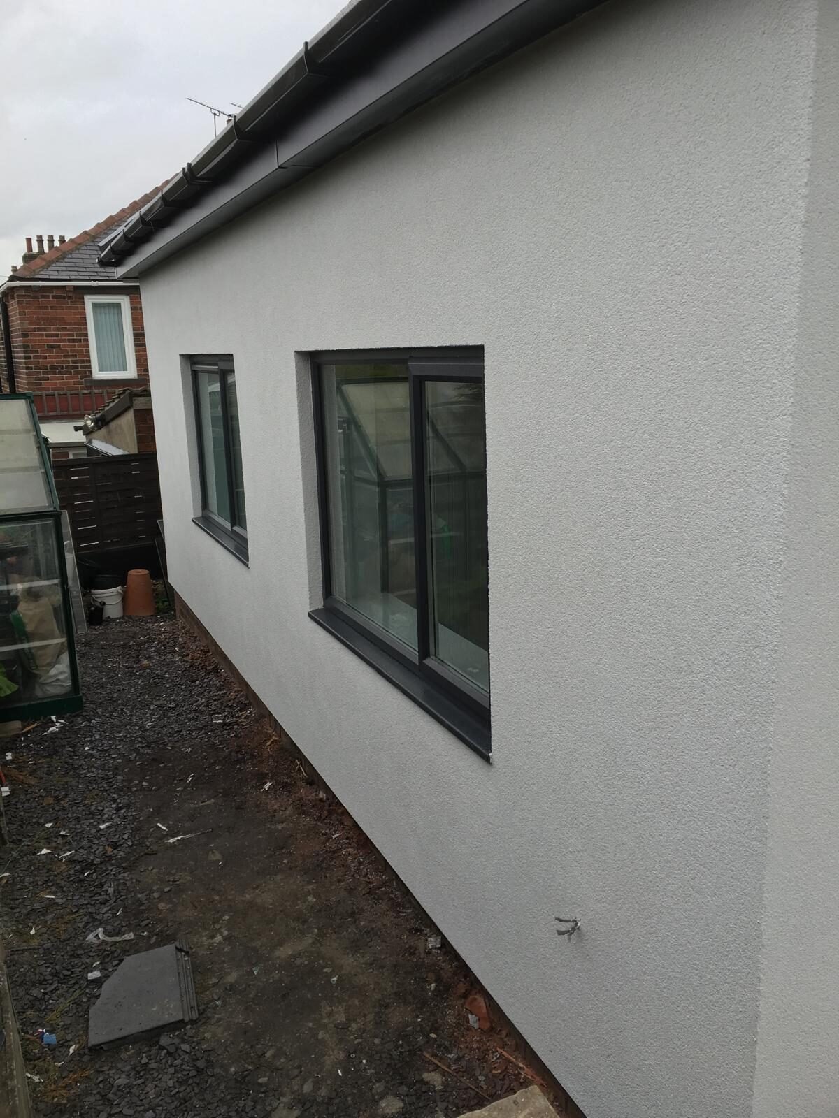White rendered bungalow side elevation with new path